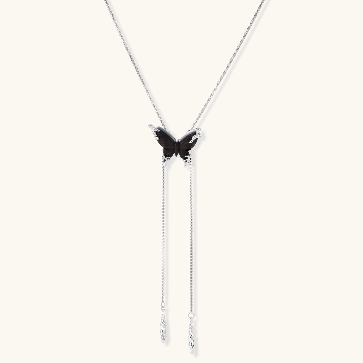 Dark wood butterfly earrings and necklace with silver chain accents on white background, showing natural grain texture.