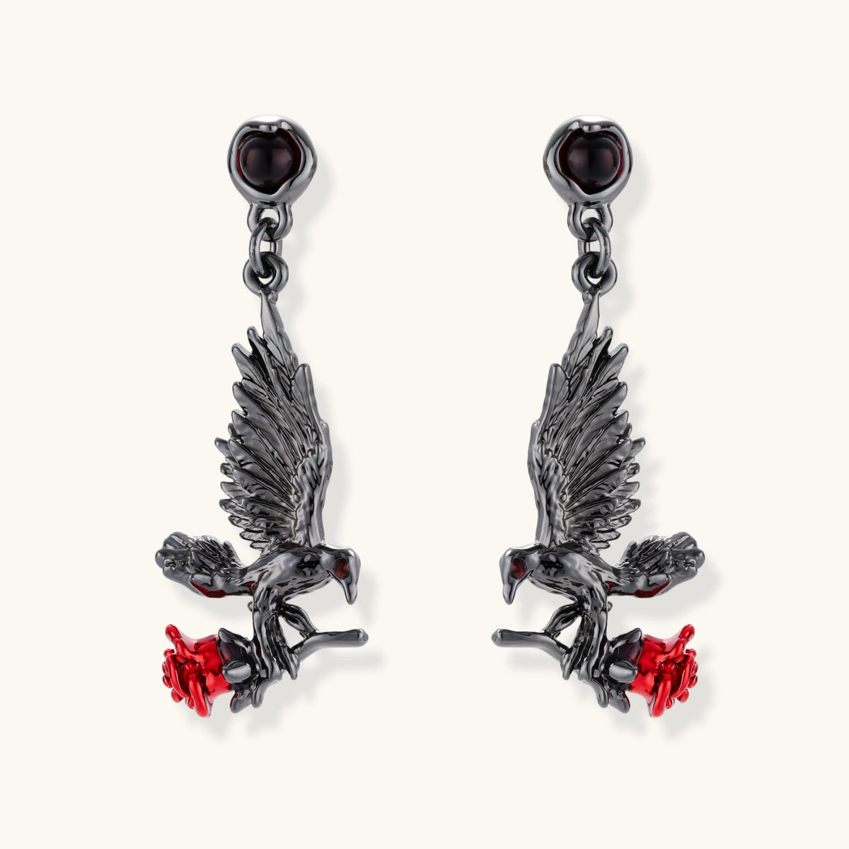 Dark gunmetal jewelry set featuring detailed raven pendants carrying red enamel roses with layered pearl and chain necklaces