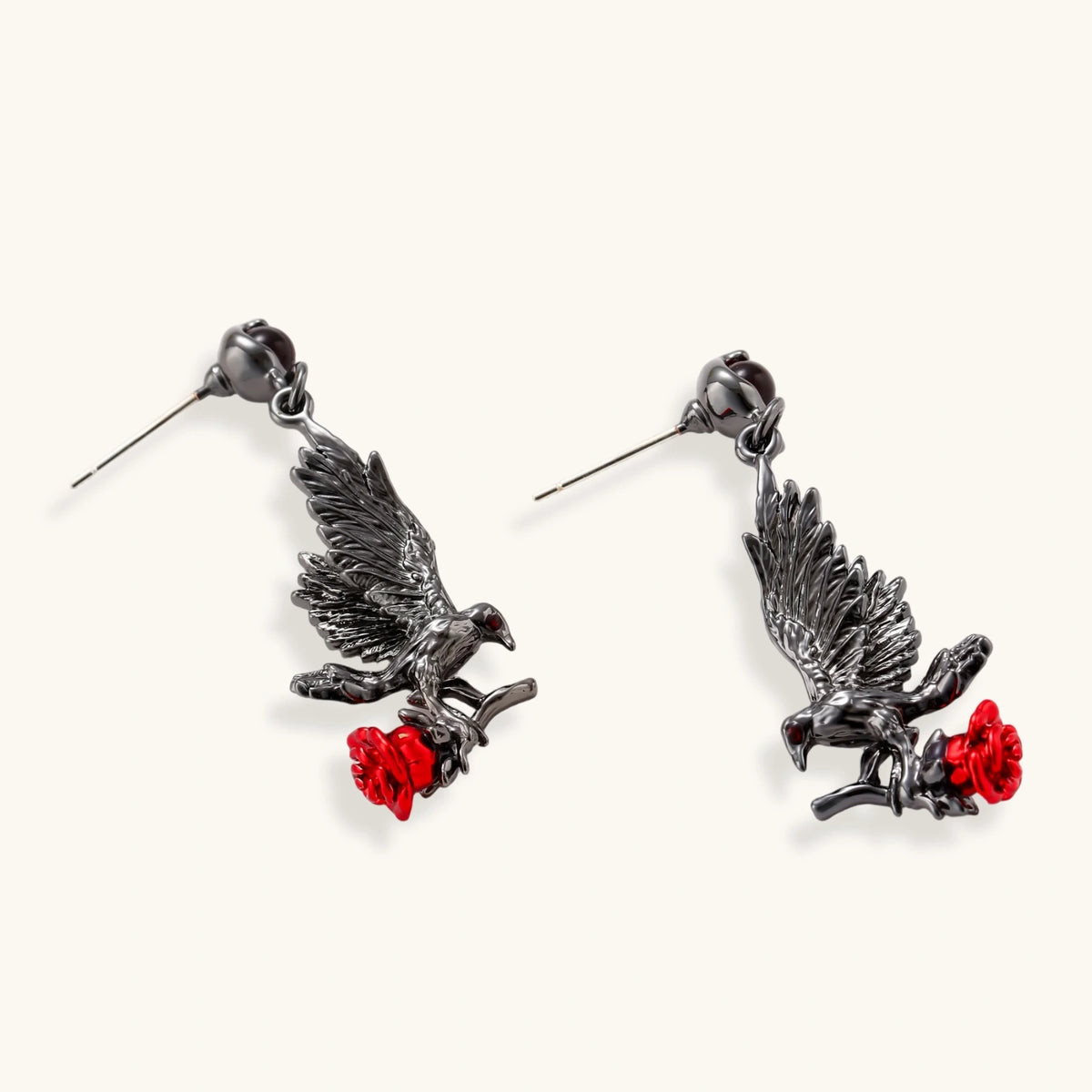 Dark gunmetal jewelry set featuring detailed raven pendants carrying red enamel roses with layered pearl and chain necklaces