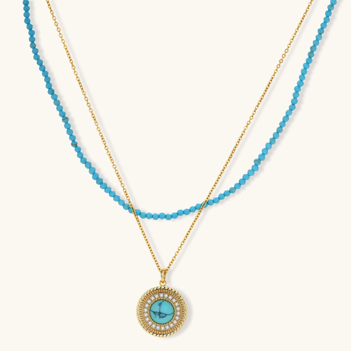 Gold-plated turquoise jewelry set with circular medallion pendant, beaded necklace, and matching stud earrings on white background